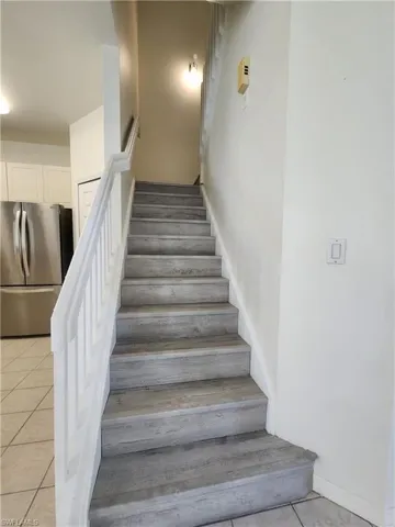 Stairway featuring tile patterned flooring and baseboards