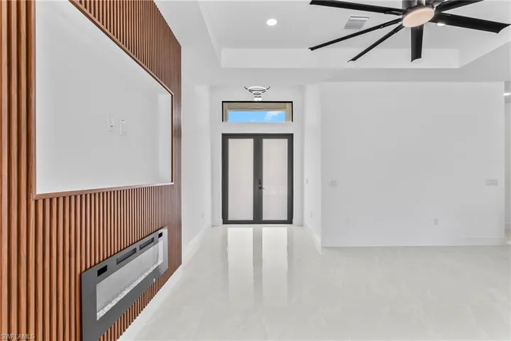 Tiled entrance foyer with a raised ceiling and ceiling fan