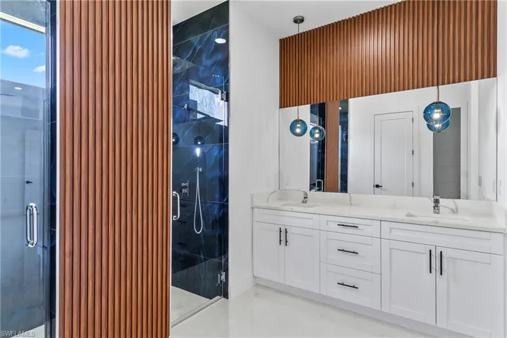 Bathroom with a shower with shower door and dual bowl vanity