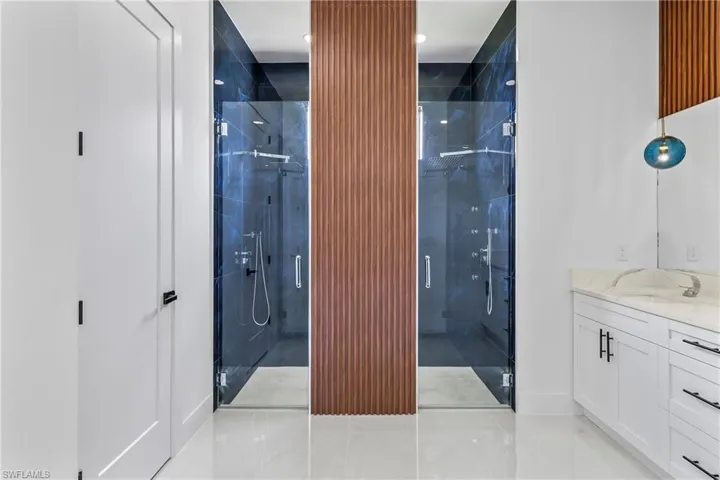 Bathroom featuring a shower with door, vanity, and tile patterned floors