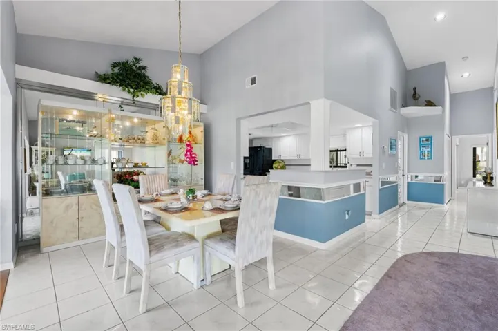 Dining room featuring light tile patterned floors and high vaulted ceiling