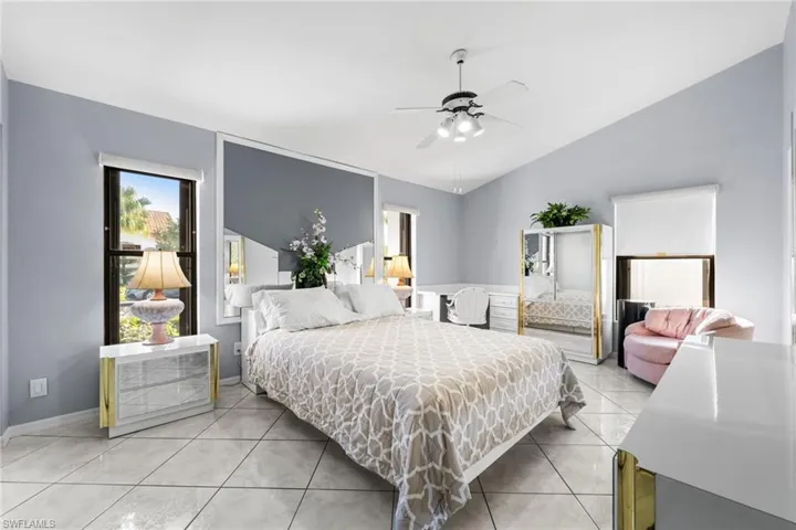 Tiled bedroom featuring ceiling fan and lofted ceiling