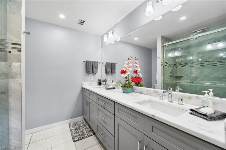 Bathroom with vanity, tile patterned floors, and an enclosed shower