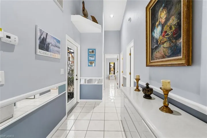 Hallway featuring light tile patterned floors, french doors, and a wealth of natural light