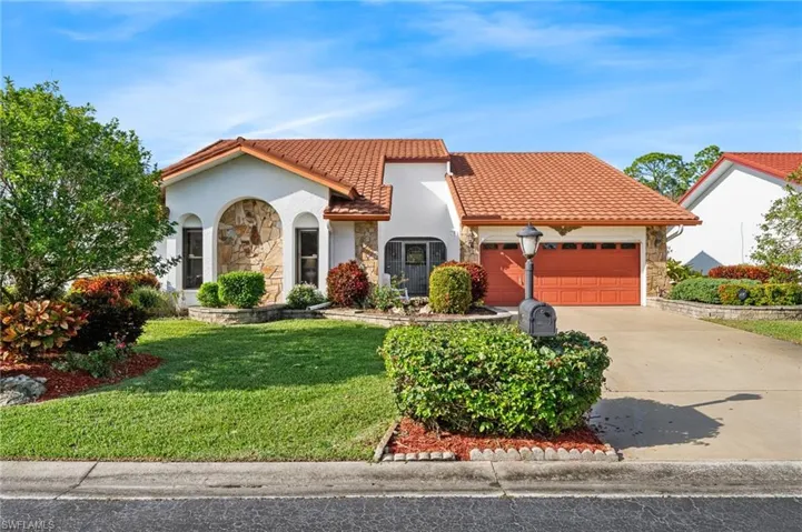 Mediterranean / spanish-style home featuring a front yard and a garage