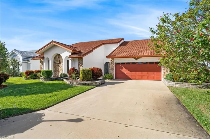 Mediterranean / spanish house featuring a front lawn and a garage