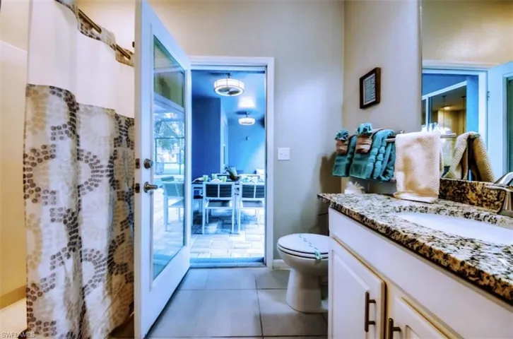 Full bathroom featuring curtained shower, vanity, and light tile patterned floors