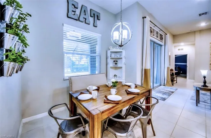 Dining space with a chandelier and tile patterned flooring