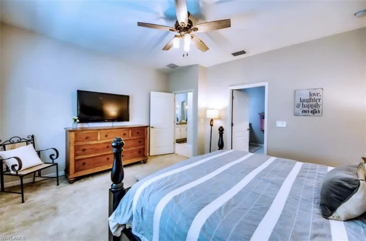 Carpeted bedroom featuring ceiling fan