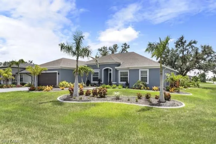 Ranch-style house featuring a garage, a front lawn, and stucco siding