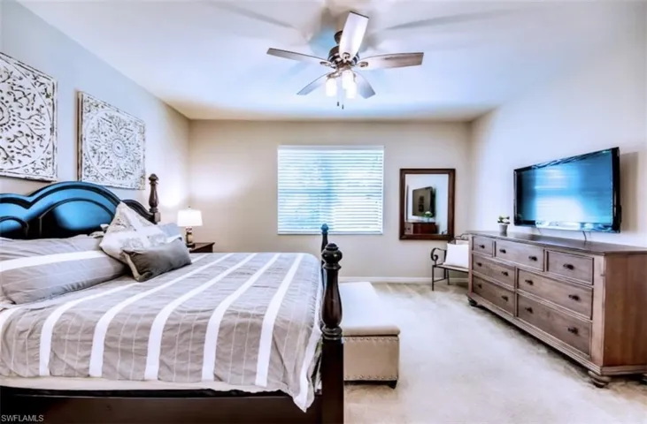 Bedroom featuring light colored carpet and a ceiling fan