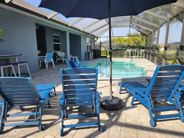 Outdoor pool featuring a patio, a sunroom, and a lanai