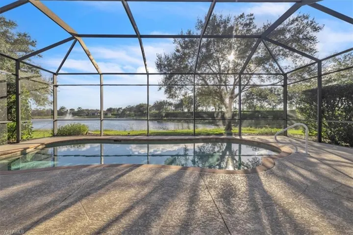 Swimming pool featuring a sunroom, a lanai, and a water view