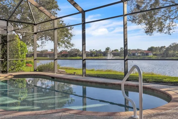 View of pool with glass enclosure and a water view