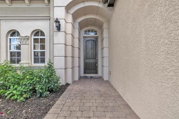Doorway to property featuring stucco siding