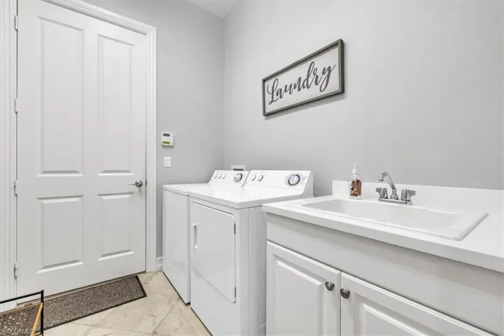 Laundry room with washer and clothes dryer and cabinet space