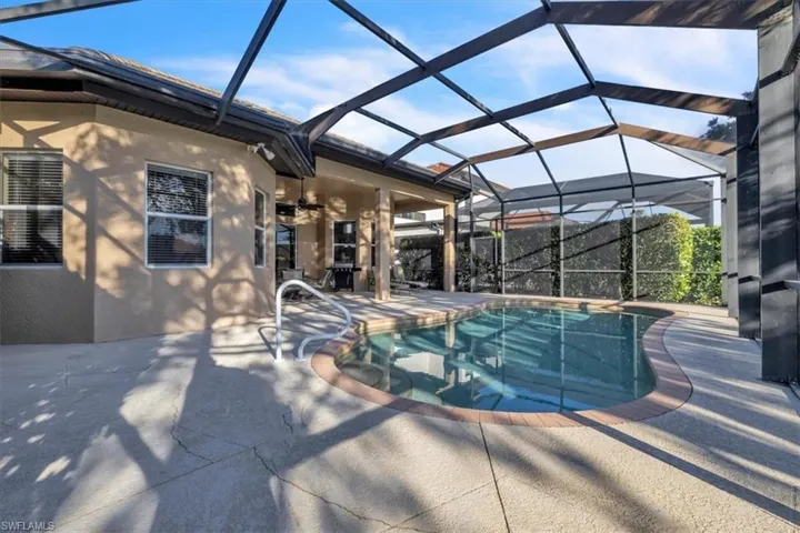 Outdoor pool with a lanai, a sunroom, and a patio area