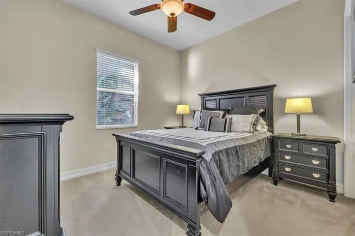 Bedroom with ceiling fan and light carpet
