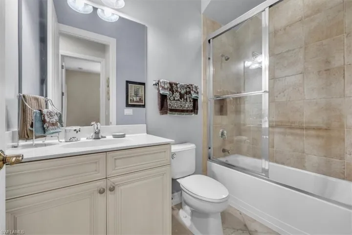 Full bathroom with enclosed tub / shower combo and vanity