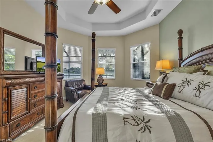Master Suite bedroom with a tray ceiling and ceiling fan