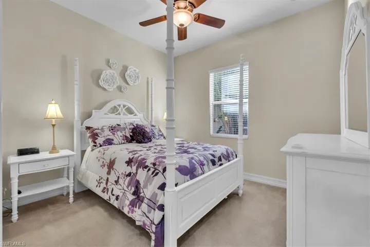 Bedroom with light carpet and a ceiling fan