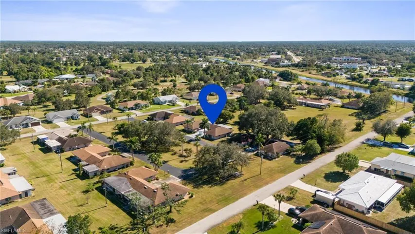 Aerial view of property and surrounding area with nearby suburban area and a large body of water