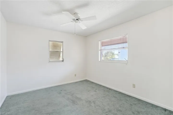 Spare room with carpet floors, a textured ceiling, and a ceiling fan
