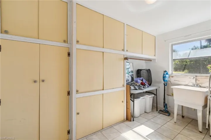 Washroom featuring cabinet space and light tile patterned floors