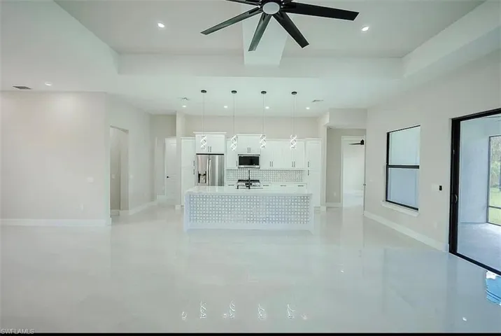 Unfurnished living room featuring ceiling fan