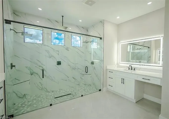 Bathroom featuring vanity and a shower with door