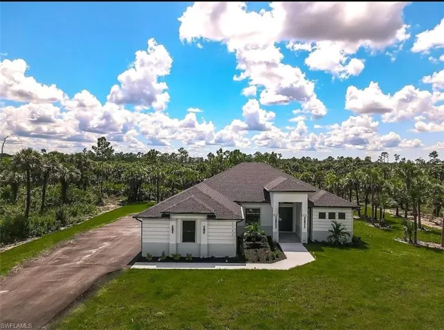 Ranch-style home featuring a front lawn