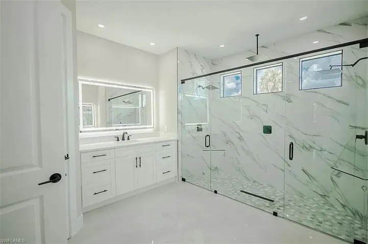 Bathroom featuring vanity and a shower with door
