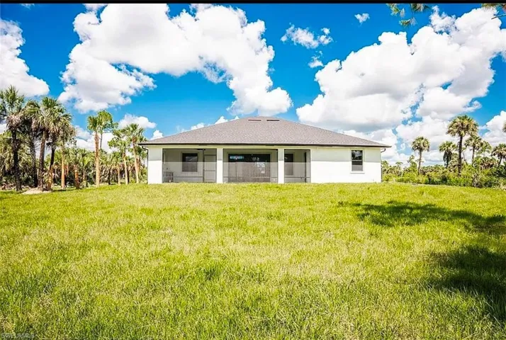 Rear view of property with a yard