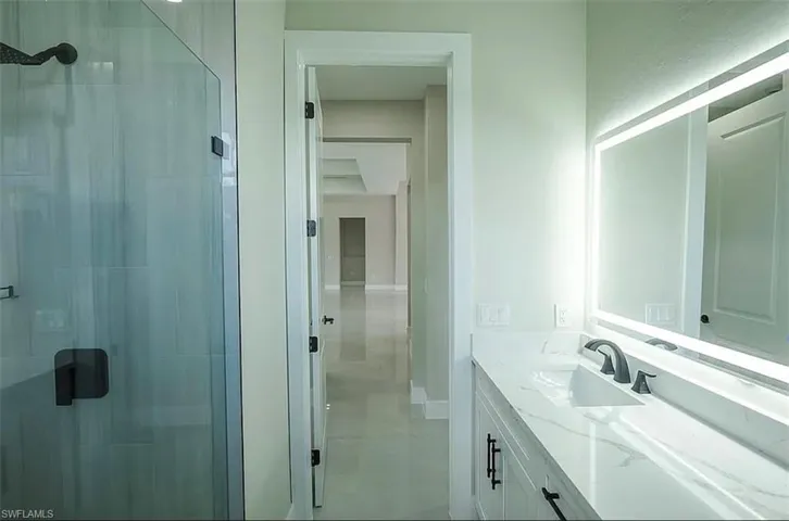 Bathroom with vanity and a shower with shower door