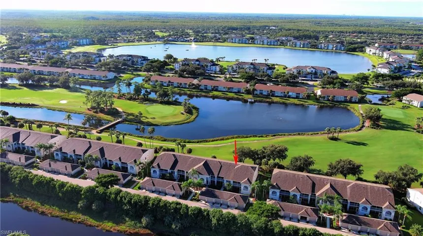 Aerial view of residential area featuring a large body of water and a golf course