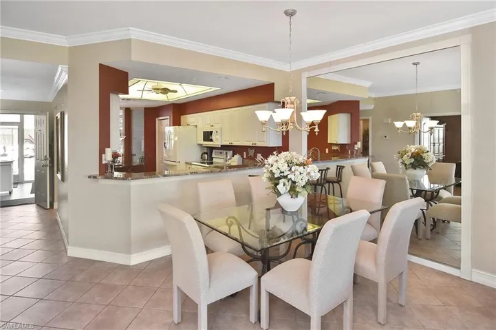 Dining room featuring ornamental molding, light tile patterned floors, and a chandelier