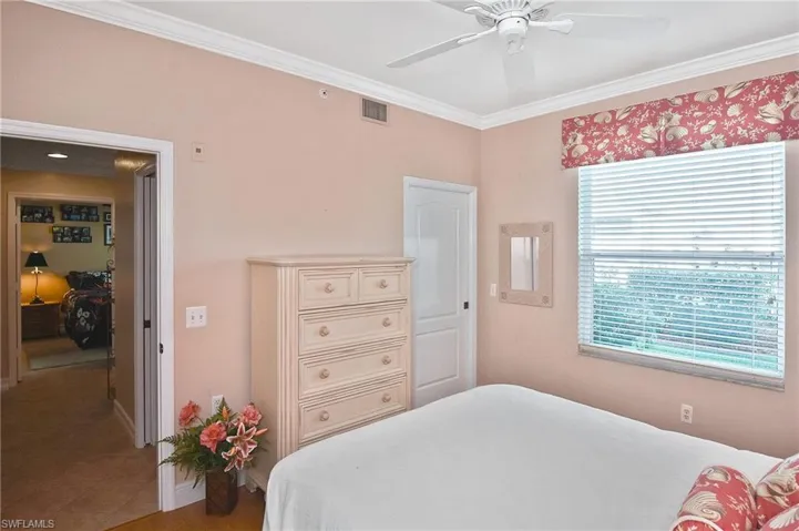 Bedroom with ornamental molding and ceiling fan