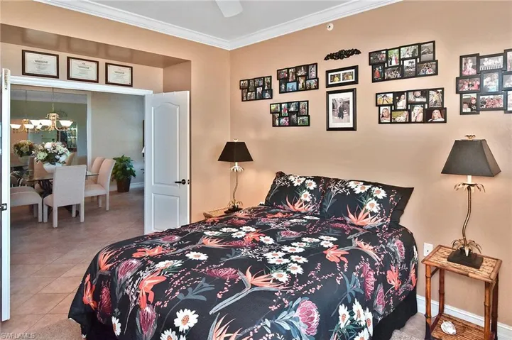 Bedroom with ornamental molding, a chandelier, light tile patterned floors, and ceiling fan