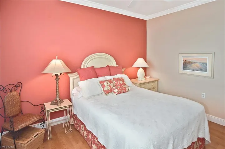 Bedroom featuring a ceiling fan, light wood finished floors, and ornamental molding