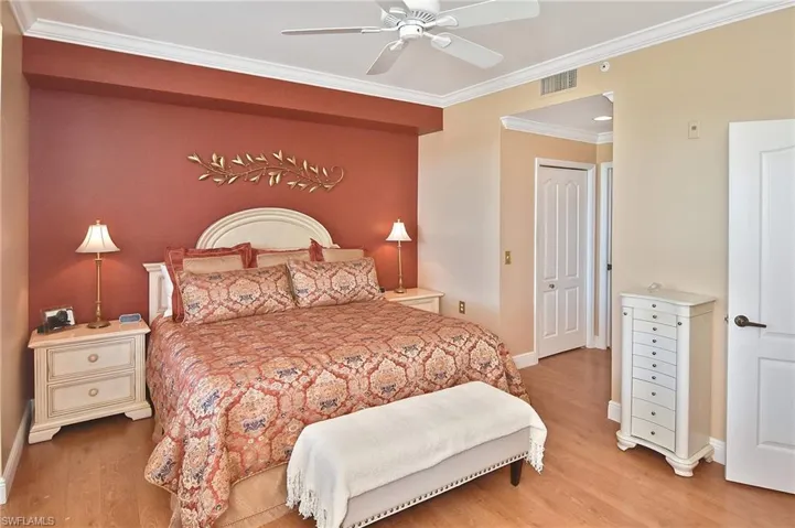 Bedroom with crown molding, light wood-type flooring, and a ceiling fan