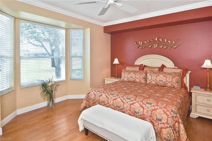 Bedroom featuring wood finished floors, ornamental molding, and ceiling fan