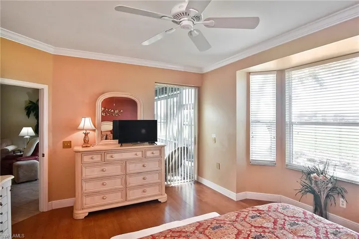 Bedroom featuring light wood-type flooring, crown molding, ceiling fan, and access to exterior