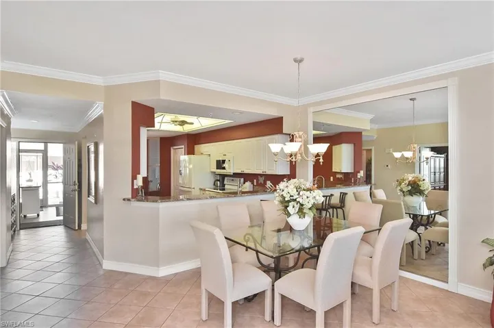 Dining space with crown molding, light tile patterned floors, and a chandelier
