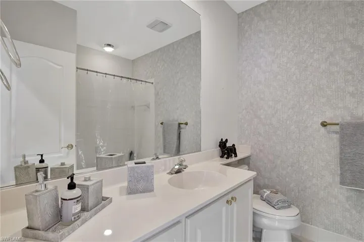 Bathroom with toilet, vanity, and walk in shower