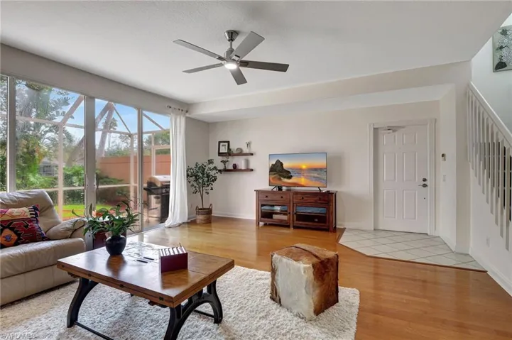 Living room with ceiling fan and light hardwood / wood-style flooring