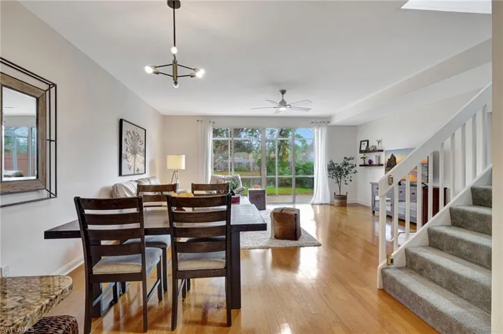 Dining room featuring ceiling fan with notable chandelier and light hardwood / wood-style flooring