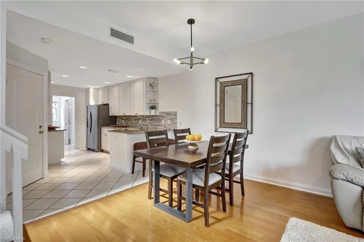 Dining room featuring sink, an inviting chandelier, and light hardwood / wood-style flooring