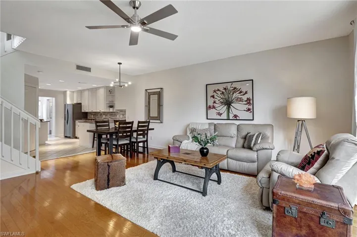Living room featuring light hardwood / wood-style floors and ceiling fan with notable chandelier
