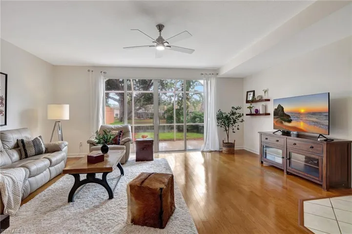 Living room with ceiling fan and light hardwood / wood-style floors