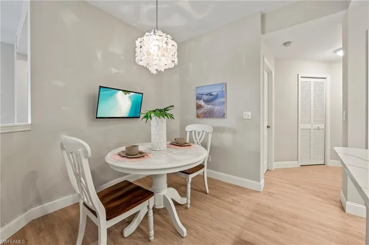 Dining space with a notable chandelier and light wood-type flooring